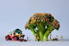A staged print with mini figures and broccoli with hundreds and thousands sprinkles by New Zealand artist Adam Popovic, available at The Little Gallery Tairua
